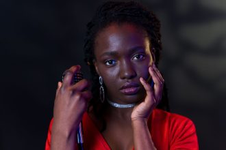 Mulher segura um microfone e posa em um retrato com expressão confiante.